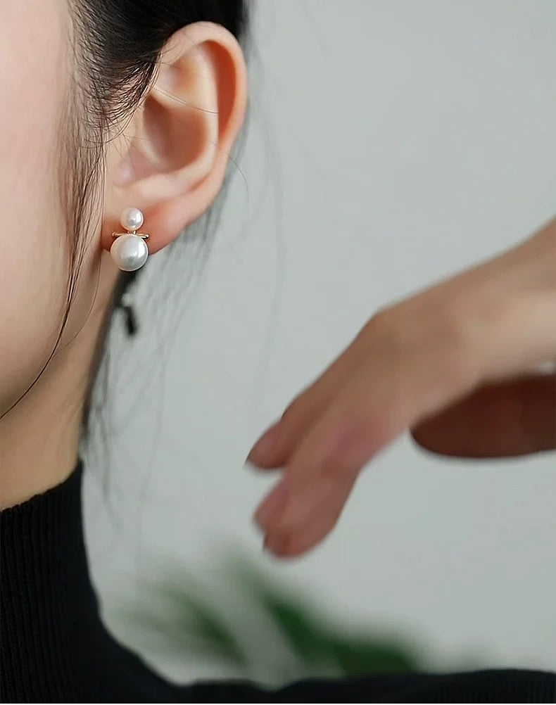 Close-up of an ear wearing a pearl earring with a blurred background