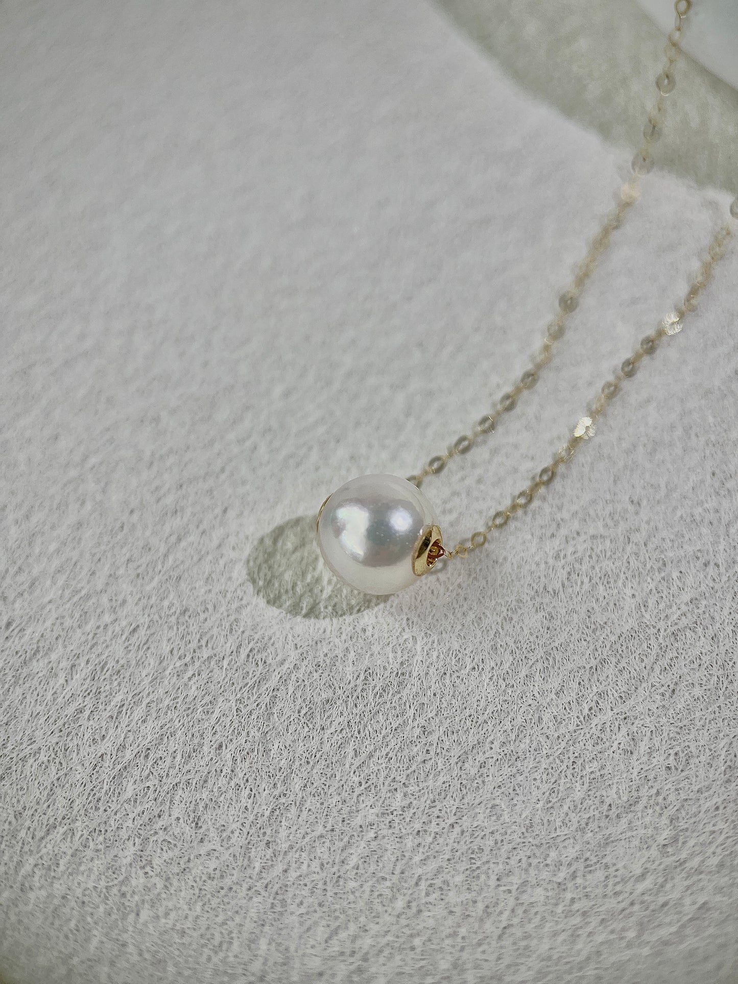 Pearl necklace on a textured gray surface
