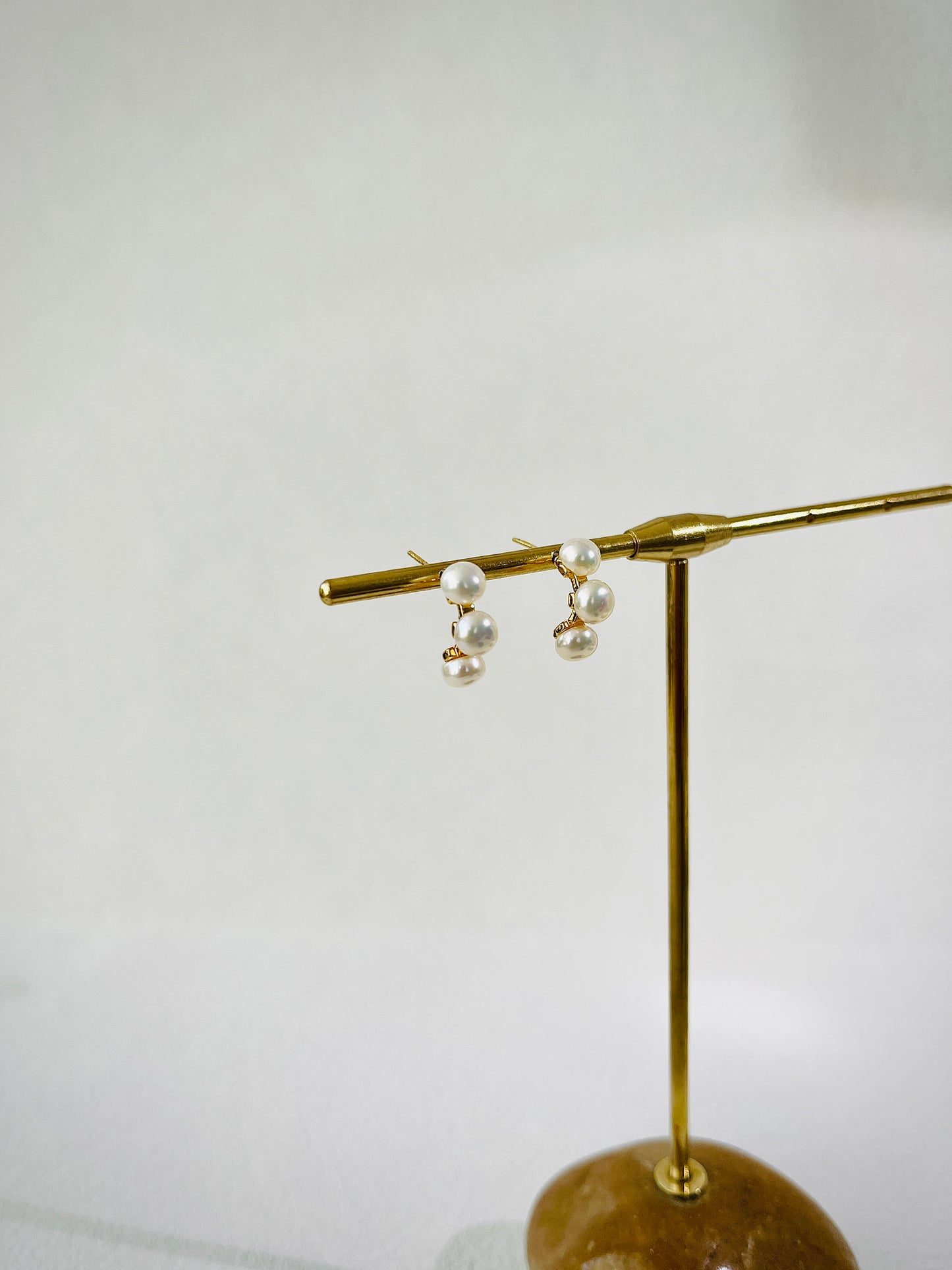 Gold earring with pearls on a white background