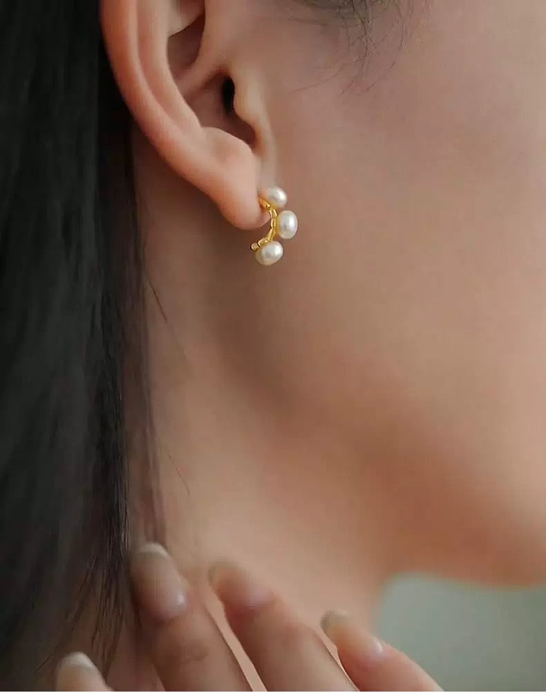 Close-up of an ear wearing a pearl earring with a blurred background
