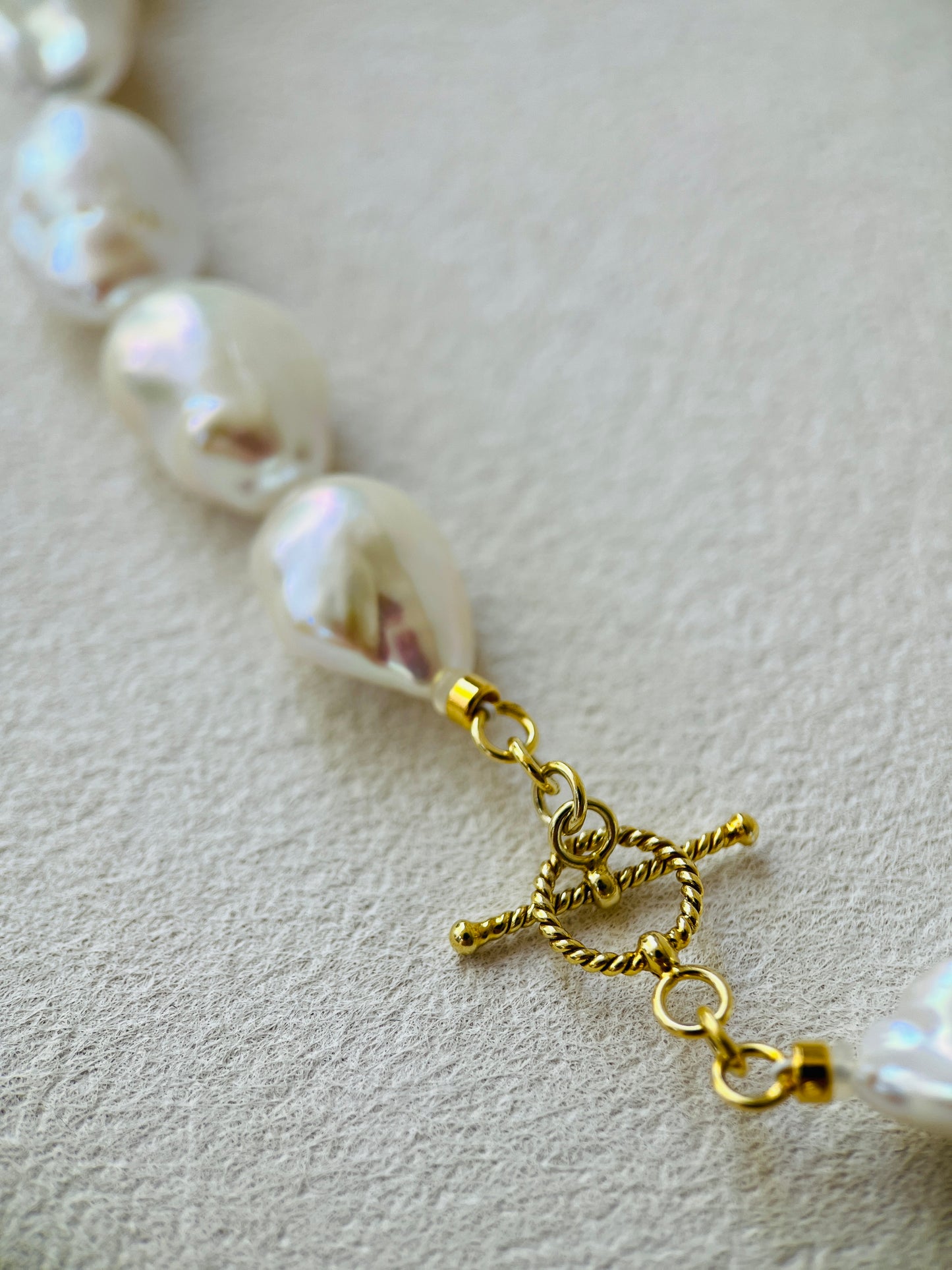 Pearl necklace with a gold clasp on a light background