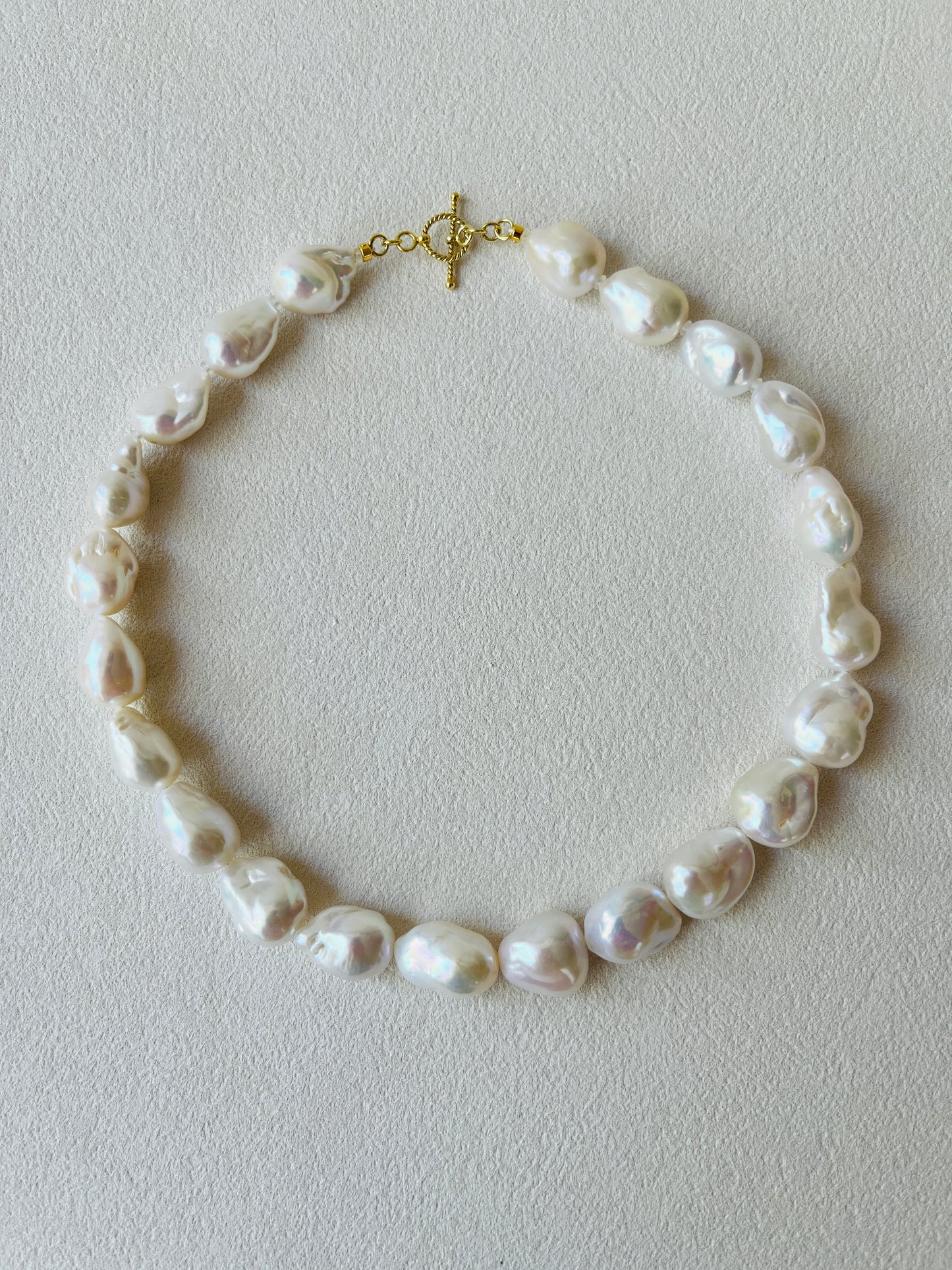 Pearl necklace on a light gray background