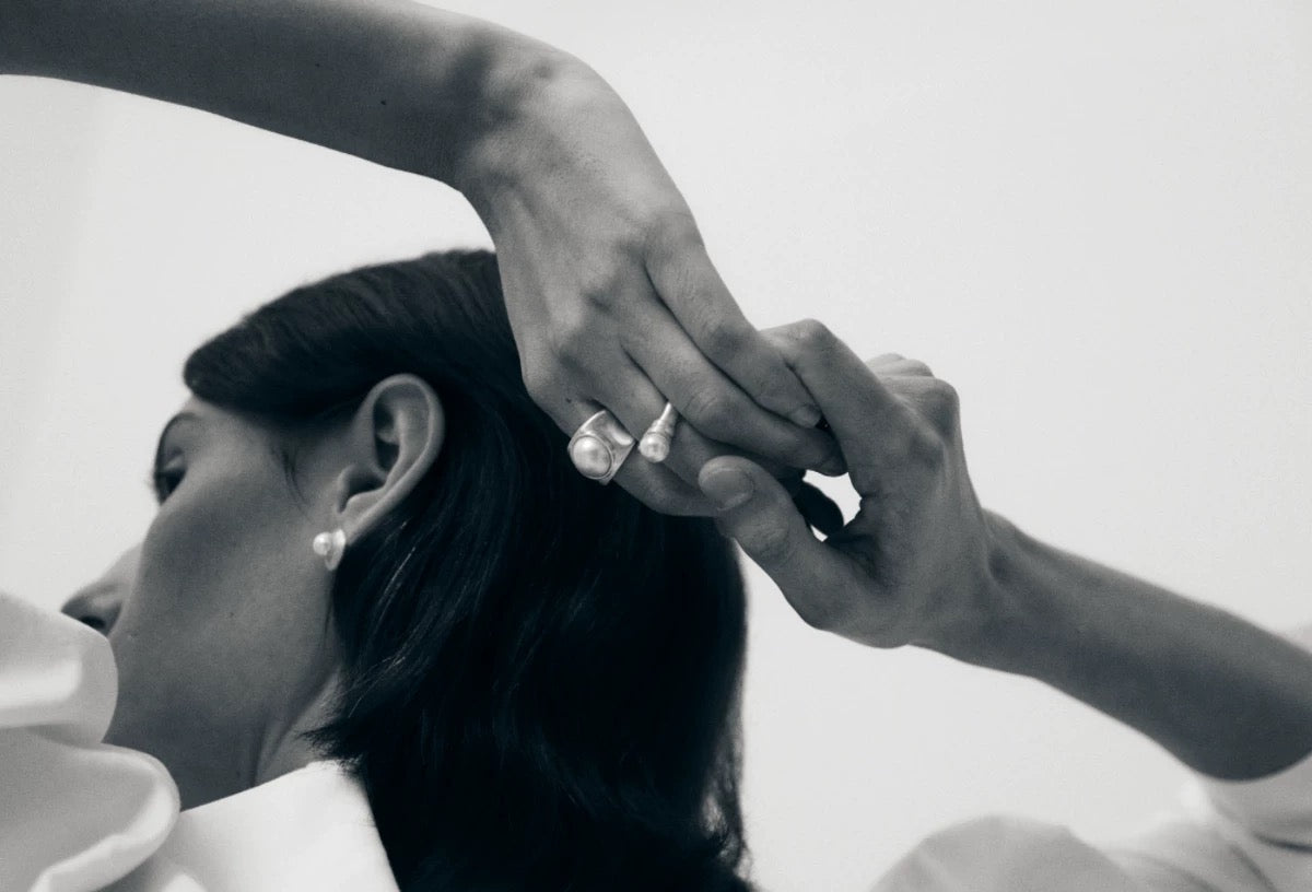 Black and white photo of a person wearing boutique pearl jewelry