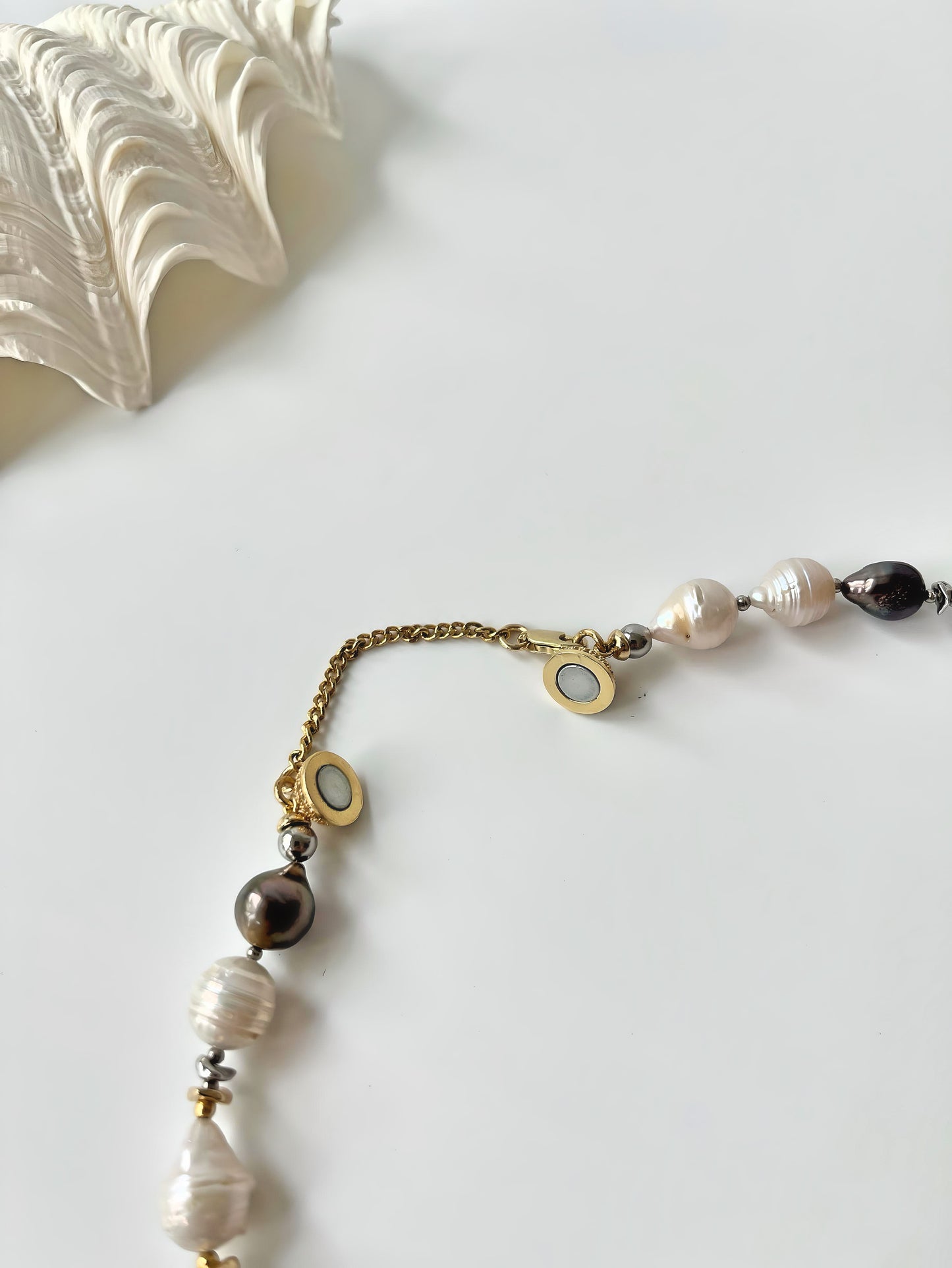 Necklace with Tahitian and South Sea pearls and gold chain on a light background