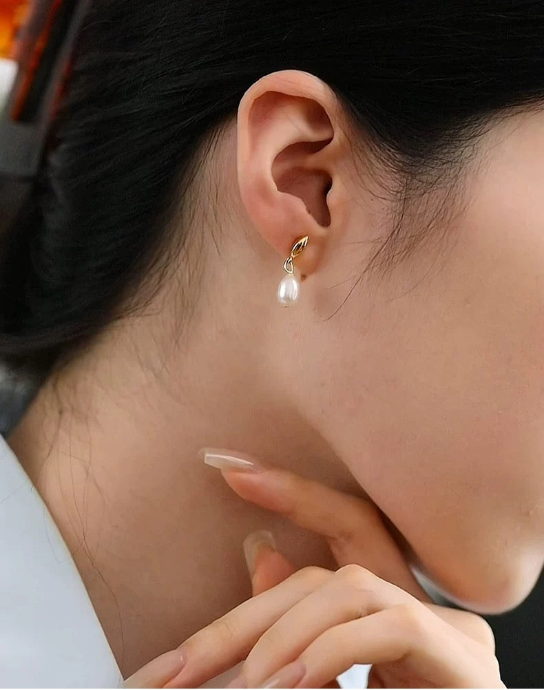 Close-up of an ear wearing a pearl earring with a blurred background