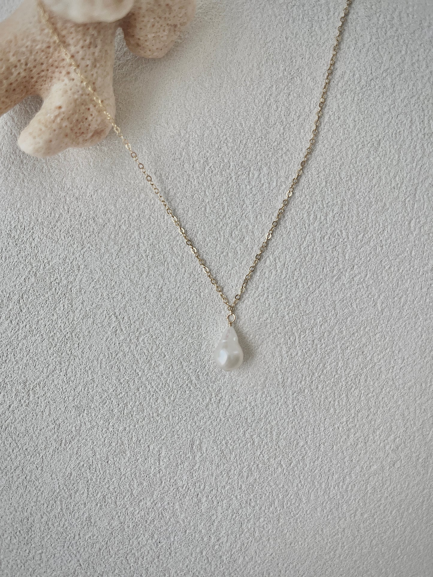 Necklace with a pendant on a textured light gray surface