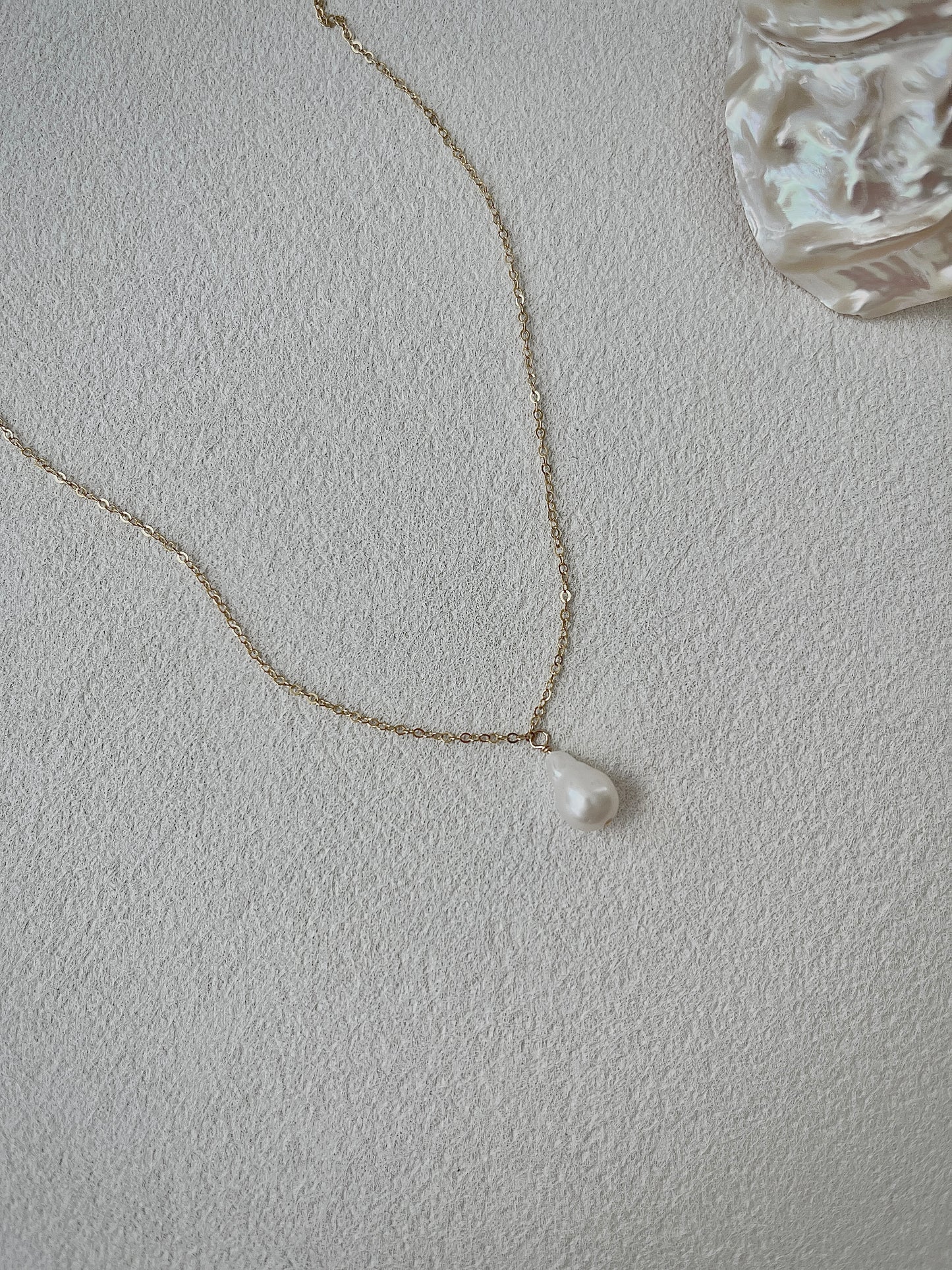 Pearl necklace on a light gray background