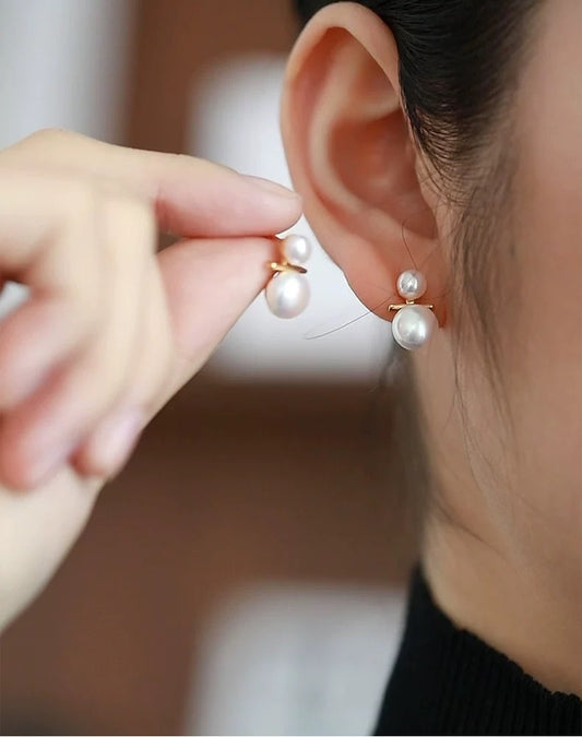 Pearl earring being worn on an ear with a blurred background