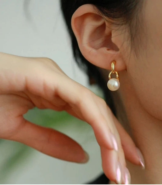 Pearl earring worn by a person with a blurred background
