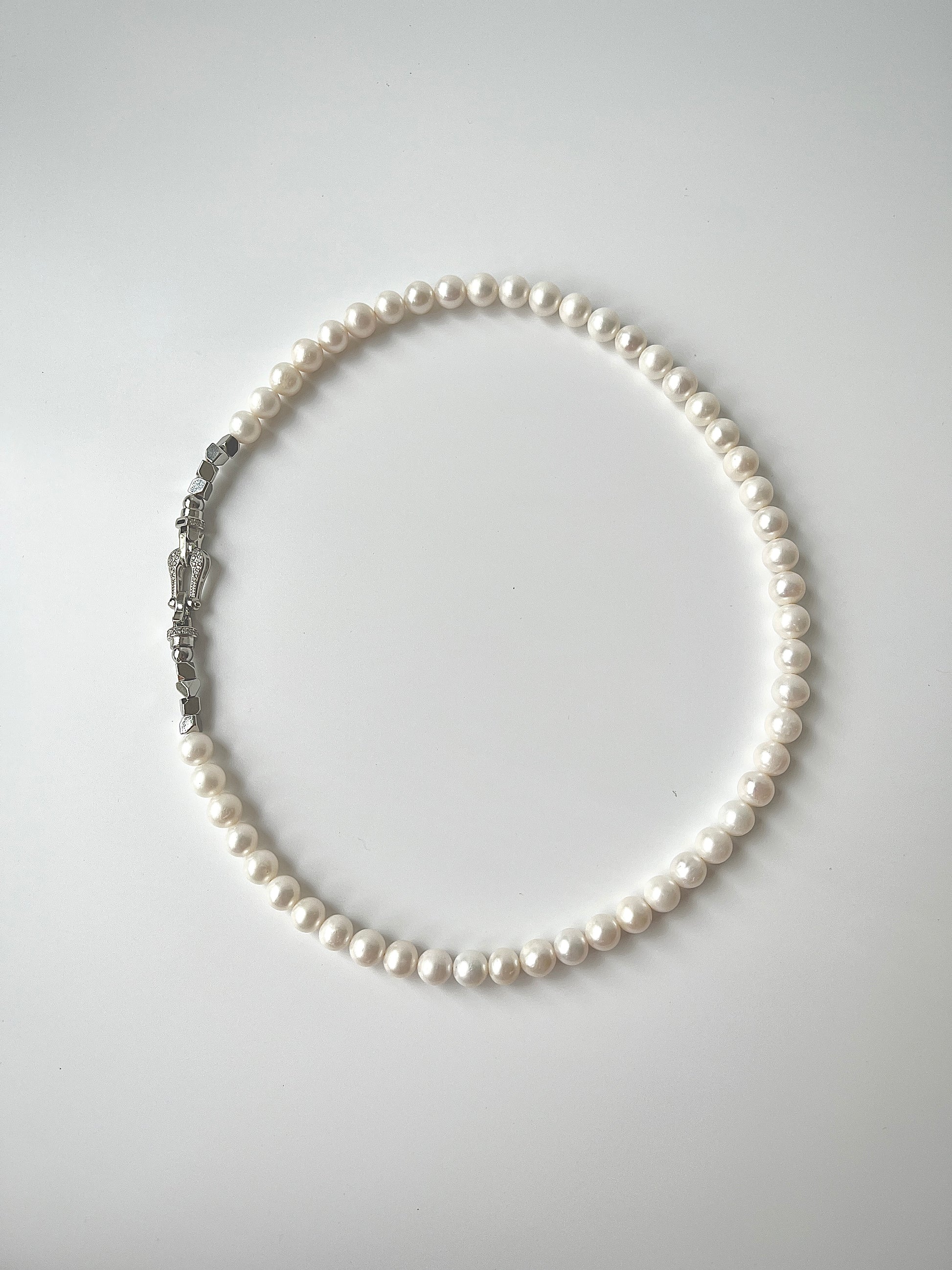 White Freshwater pearl necklace on a light gray background
