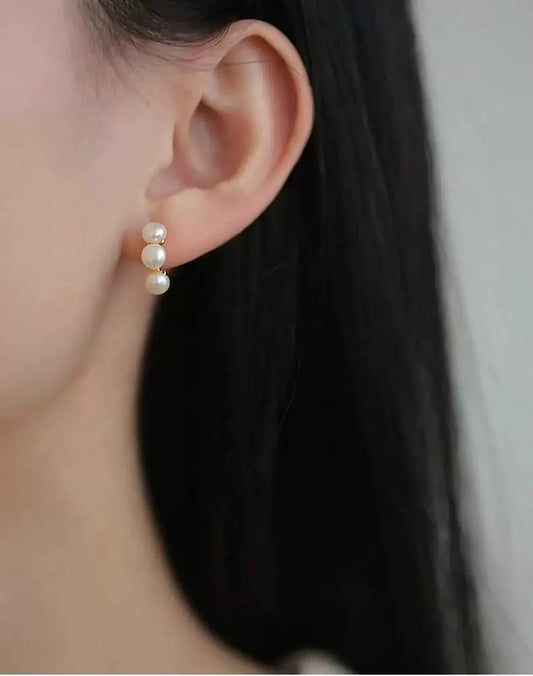 Pearl earring worn by a person with a neutral background