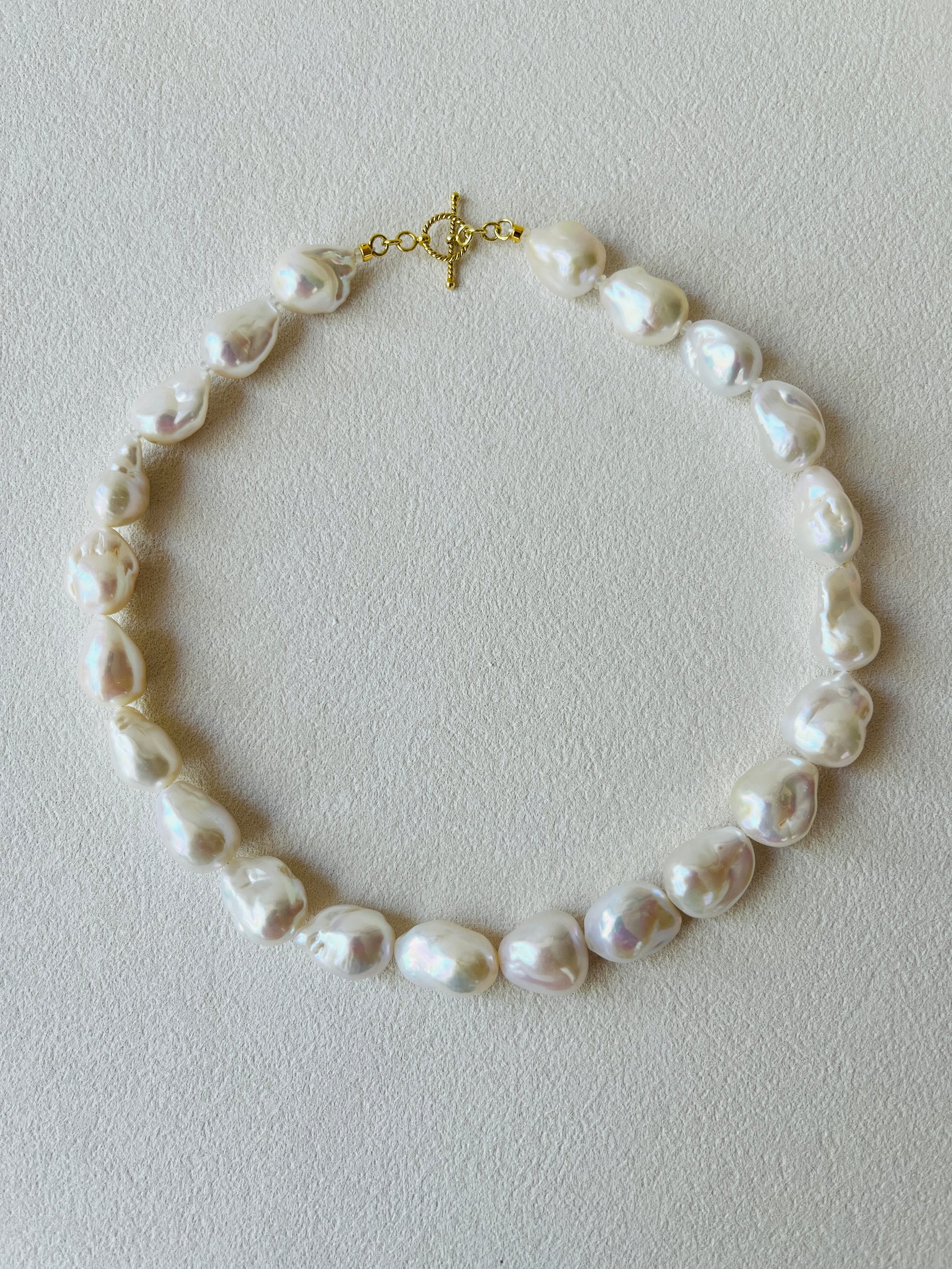 Pearl necklace on a light gray background