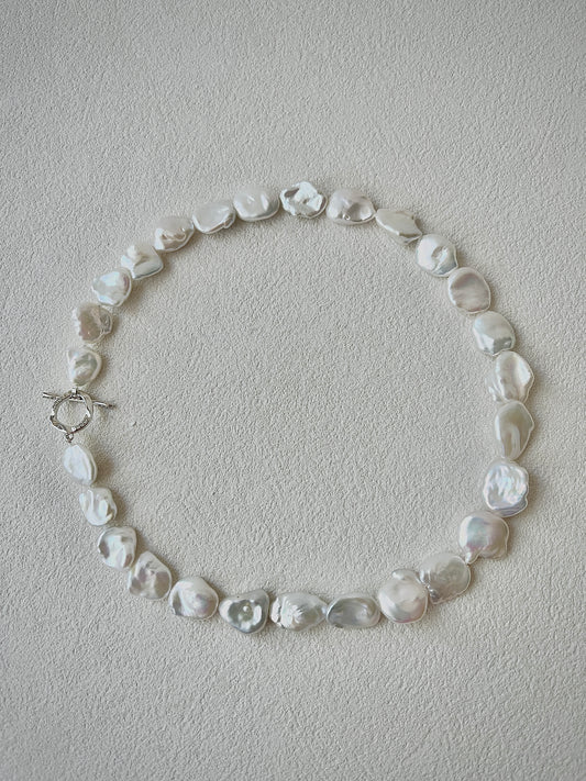 Pearl necklace on a light gray background