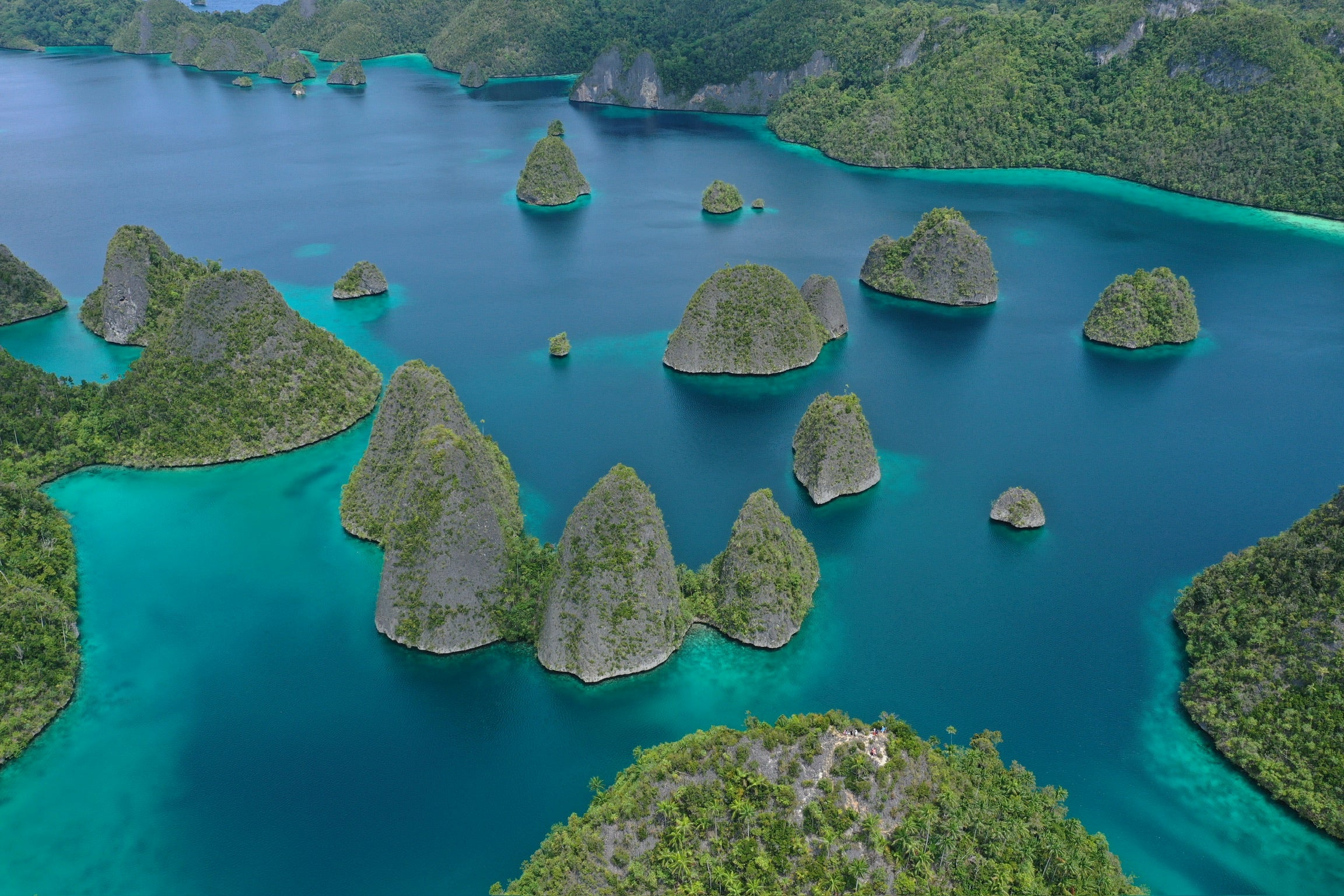 Aerial view of a tropical island archipelago with turquoise waters and green islands.