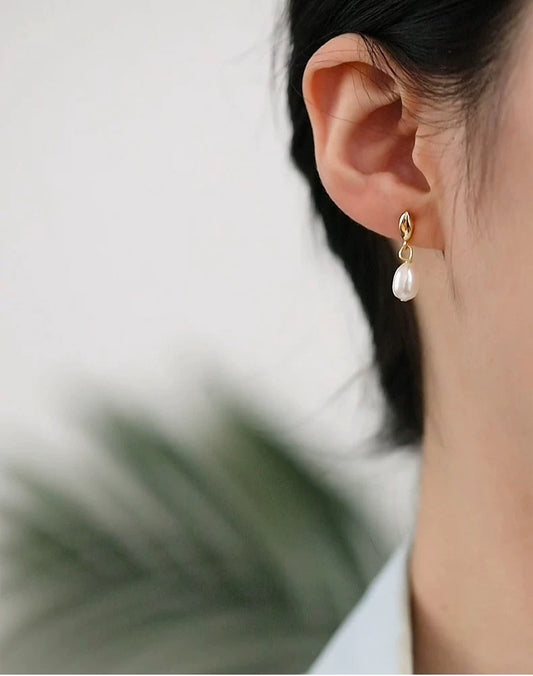 Pearl earring worn by a person with a blurred background