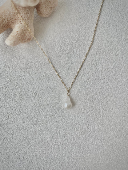 Necklace with a pendant on a textured light gray surface