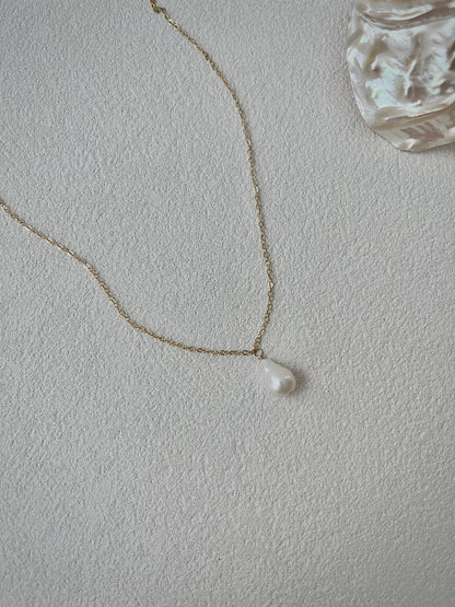 Pearl necklace on a light gray background