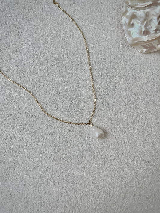 Pearl necklace on a light gray background